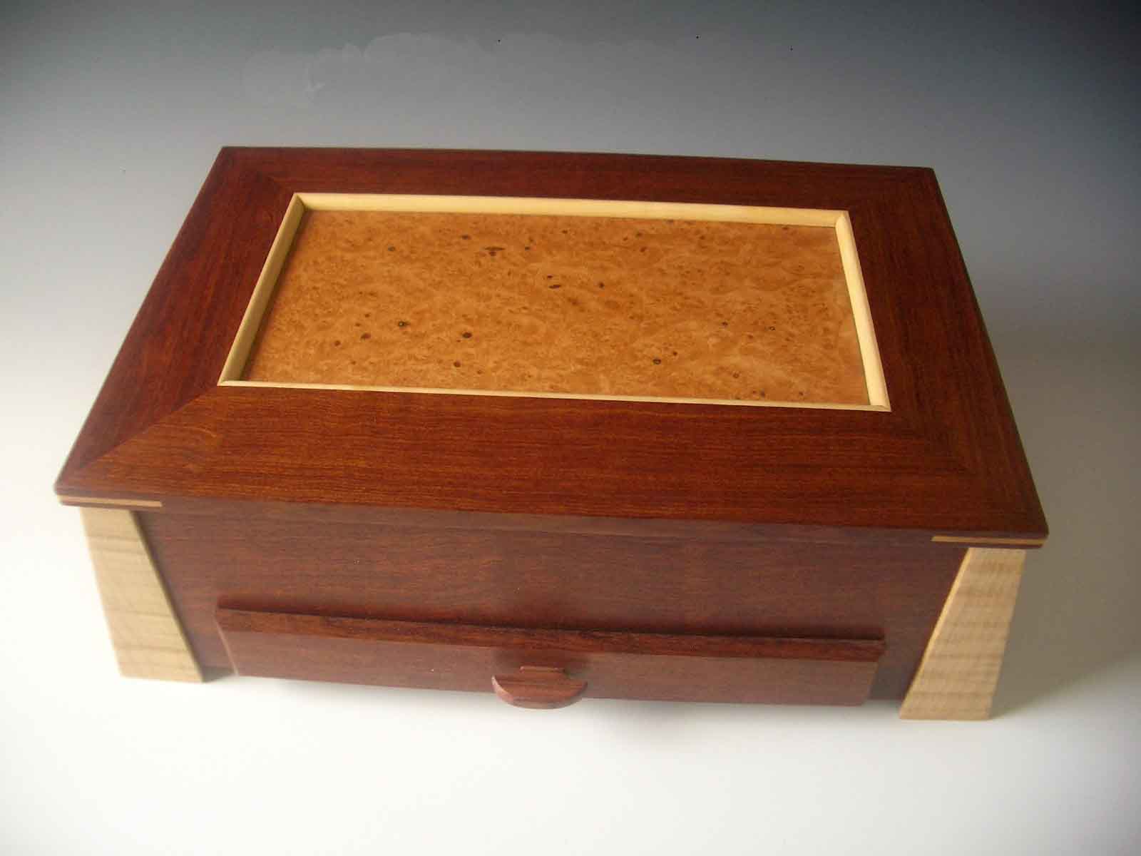 Box-shaped jewelry box with angled legs, a lid that lifts up and a drawer that pulls out